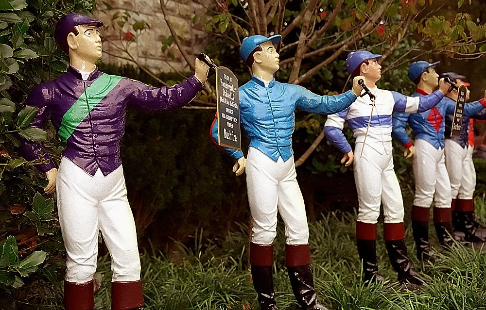 Row of painted jockey statues in colorful racing silks at Keeneland in Lexington, Kentucky